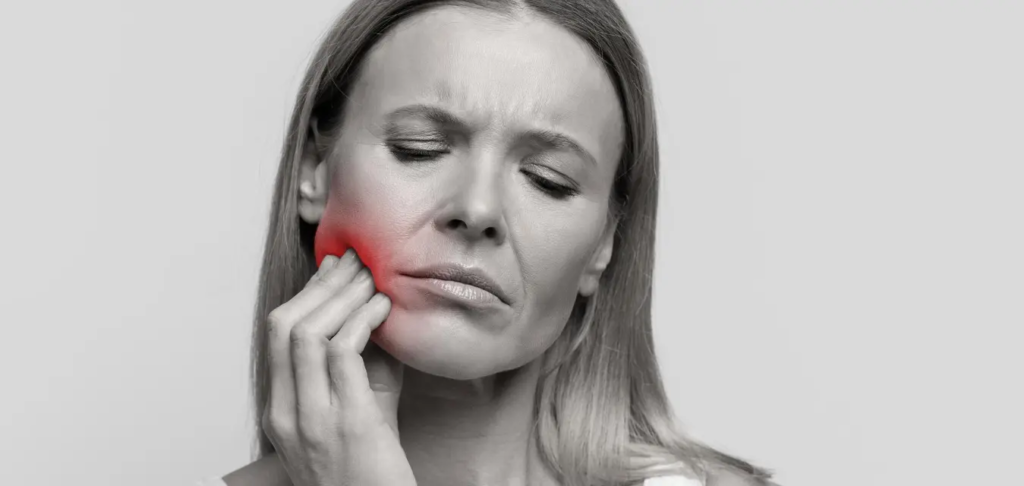 harakterystyczny ból dziąseł i tkanek przyzębia - jeden z pierwszych objawów paradontozy, który wymaga pilnej konsultacji stomatologicznej w SmileClinic w celu zatrzymania postępu choroby.